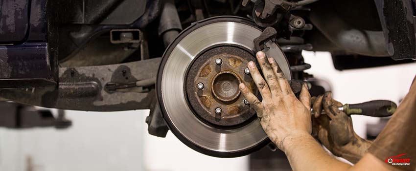 NCC-Car mechanic replacing pads for car break