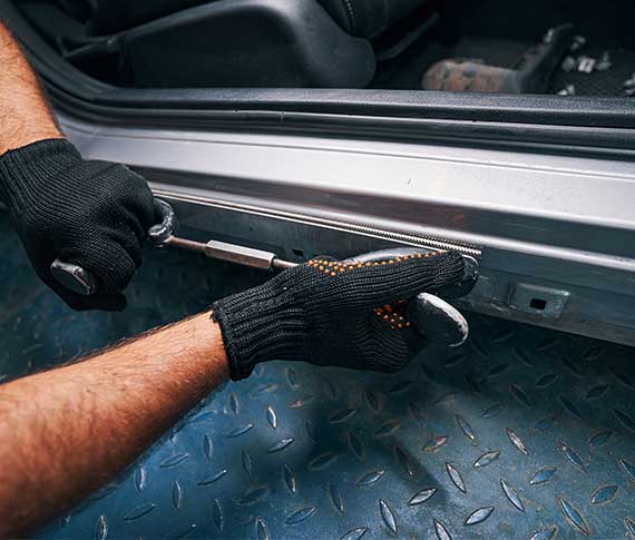 NCC Person holding straightening tool pressed to car side door frame
