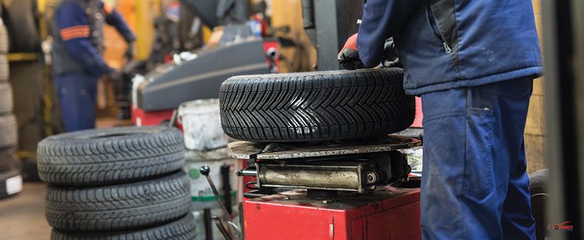 Professional auto mechanic replacing tire